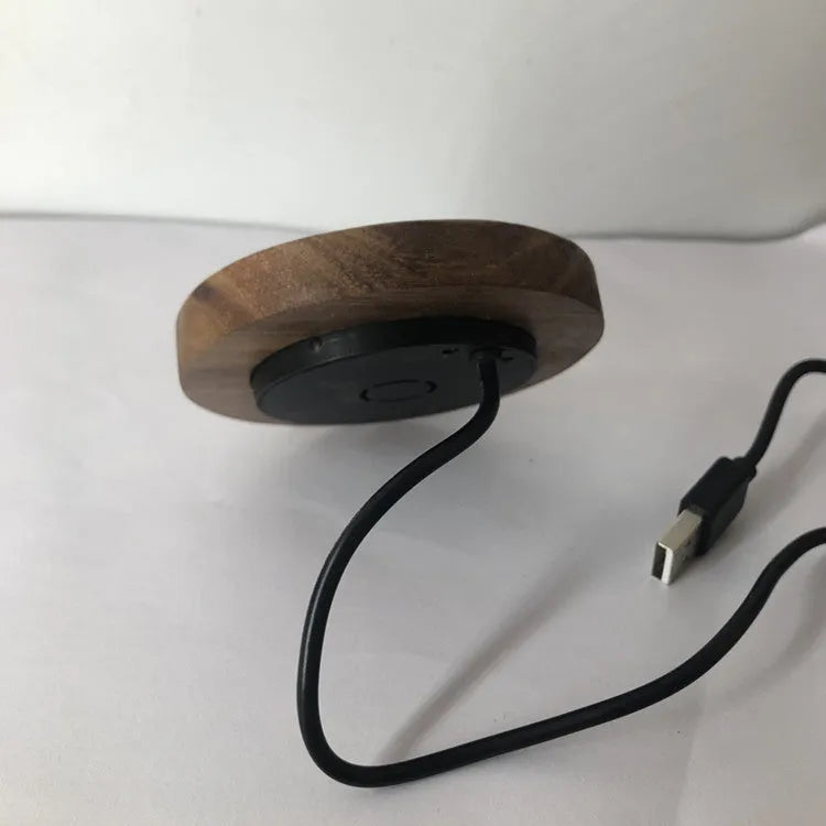 Black round 60mm wireless charging pad for embedded installation in desks and furniture.
