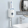A blue automatic toothpaste dispenser mounted on a bathroom wall with a soft-touch button.