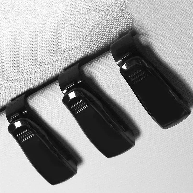 Black plastic multifunctional clip for car sunshade holding sunglasses and cards.