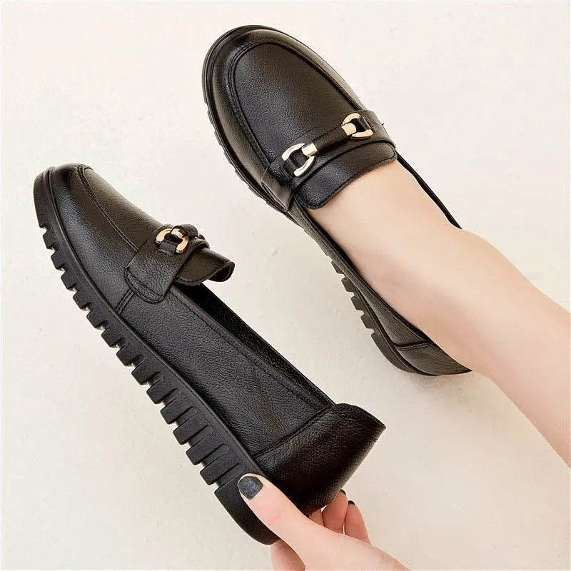 Black casual leather pumps with a soft rubber sole and low flat heel on a white background