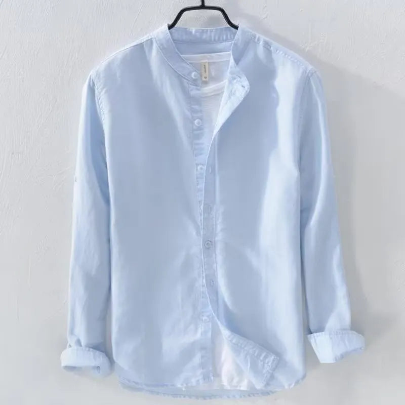 Man wearing a loose-fitting light blue long sleeve casual shirt made from cotton linen blend.
