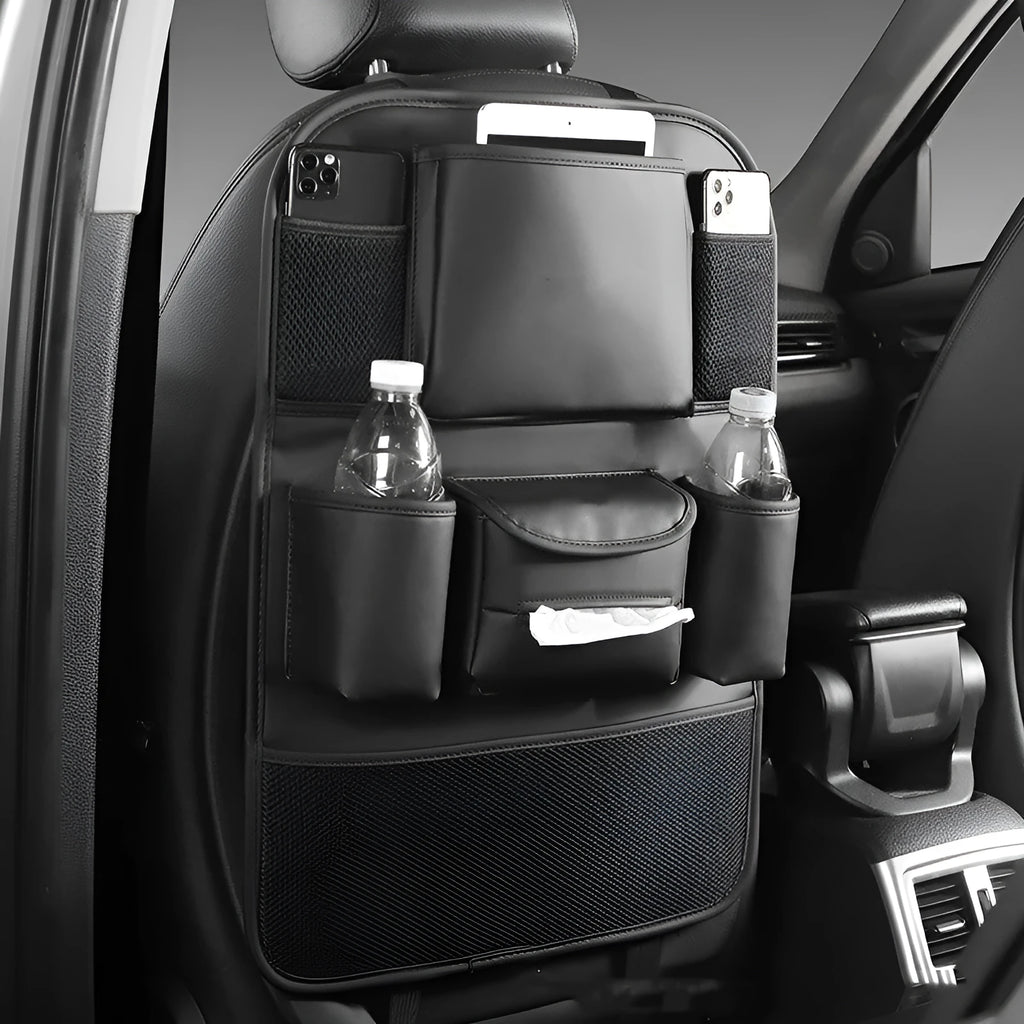 Synthetic leather car seat back storage bag hanging on the back of a grey car seat.