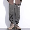 Men's grey ankle-tied straight-leg sweatpants laid flat, showing non-ironing polyester blend fabric.