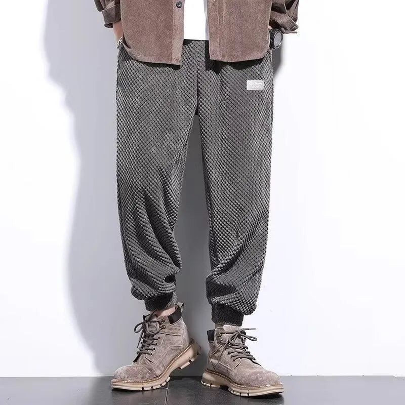 Men's grey ankle-tied straight-leg sweatpants laid flat, showing non-ironing polyester blend fabric.