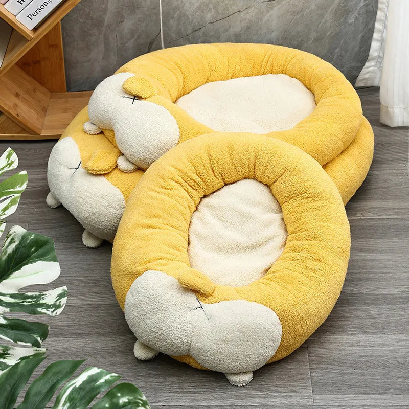 Brown and white corgi-shaped plush dog bed on a wooden floor.