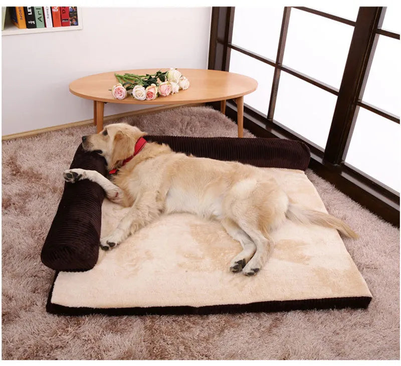 Corduroy pet sofa dog bed with a raised bolster, shown in a grey colour on a wooden floor.