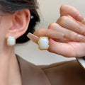 Circular geometric metal earrings with hand-woven texture in a vintage Korean style.