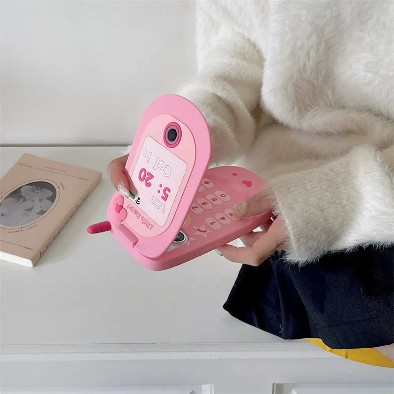 Light pink silicone flip phone case with built-in mirror for iPhone, showing cute cartoon design.