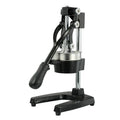 Black and white manual cast iron citrus juicer with stainless steel funnel on kitchen counter