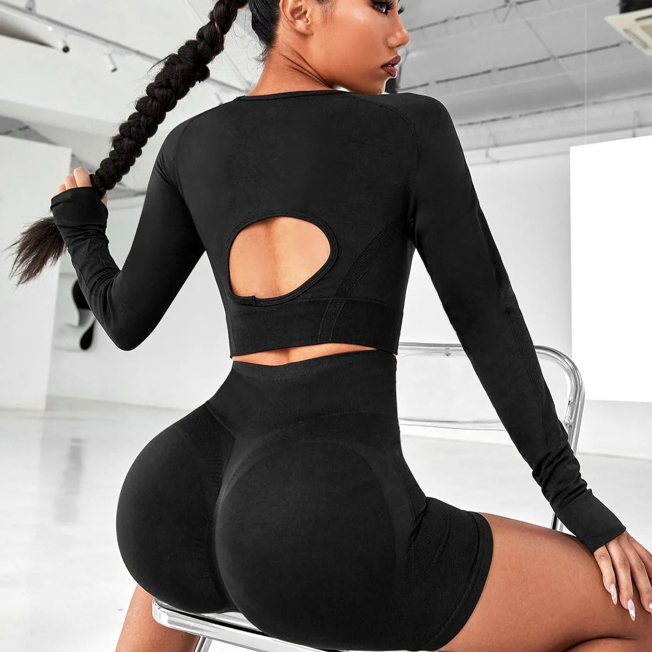 Women's black high-waist yoga suit with long sleeve top and tight-fit pants laid flat.