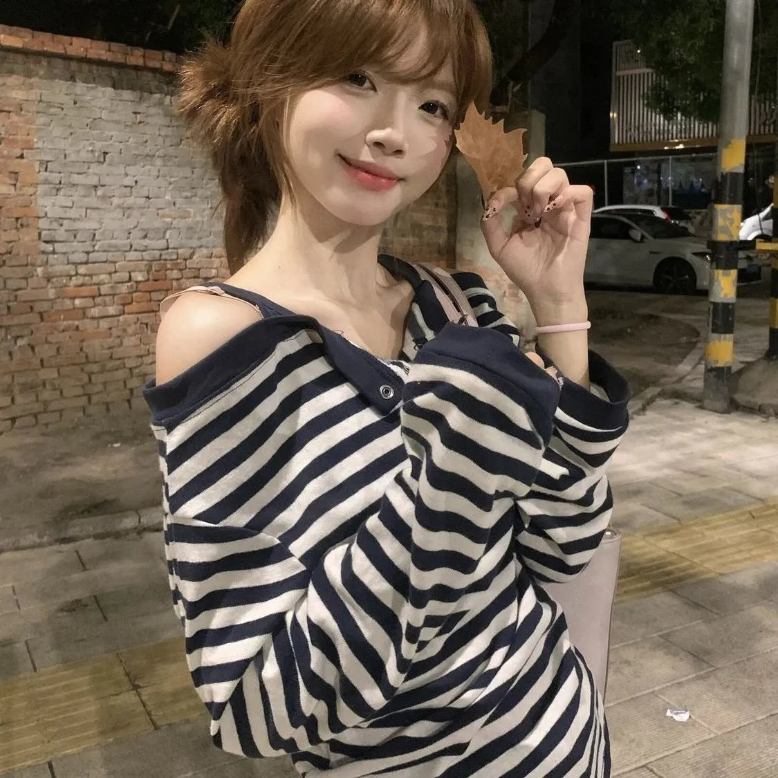 Dark blue oversized women's long-sleeved t-shirt with stripes and embroidery on a hanger.