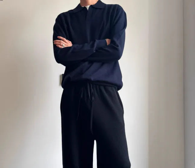 Men's navy blue loose fit wool polo sweater with a lapel collar on a hanger.