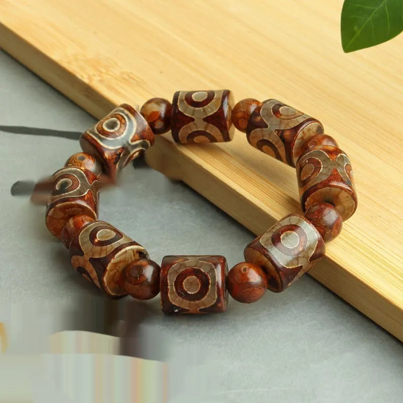 Distressed agate bracelet with traditional Tibetan dzi beads including three-eye and Nine Eyes designs.