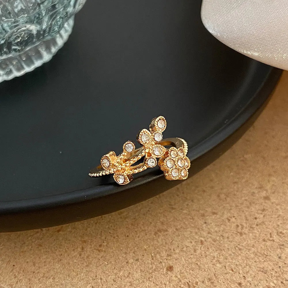 Women's open ring with diamond-treated flower and leaf design in gold colour on copper base