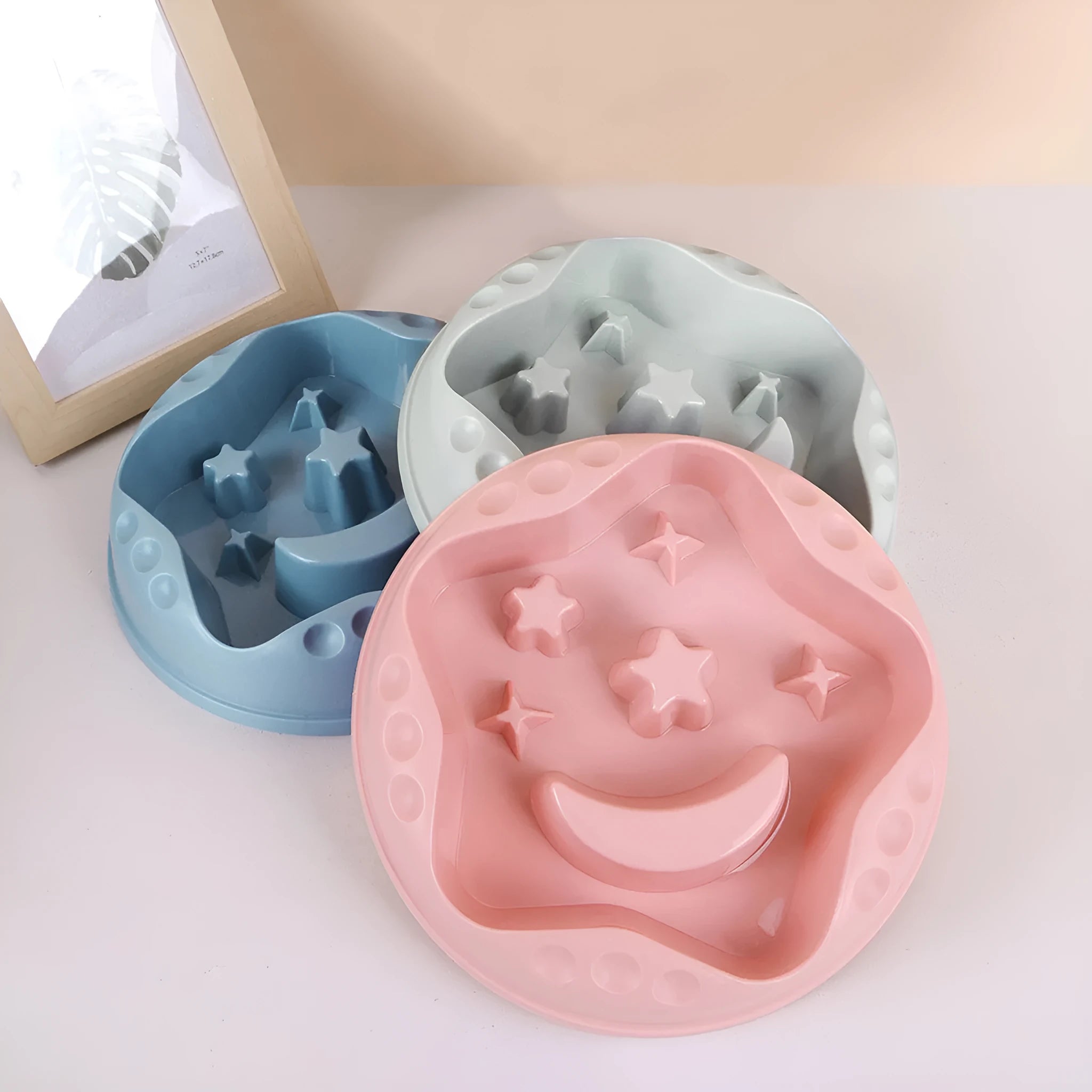 Blue plastic slow feeder dog bowl with moon, star, and wing-shaped interior ridges