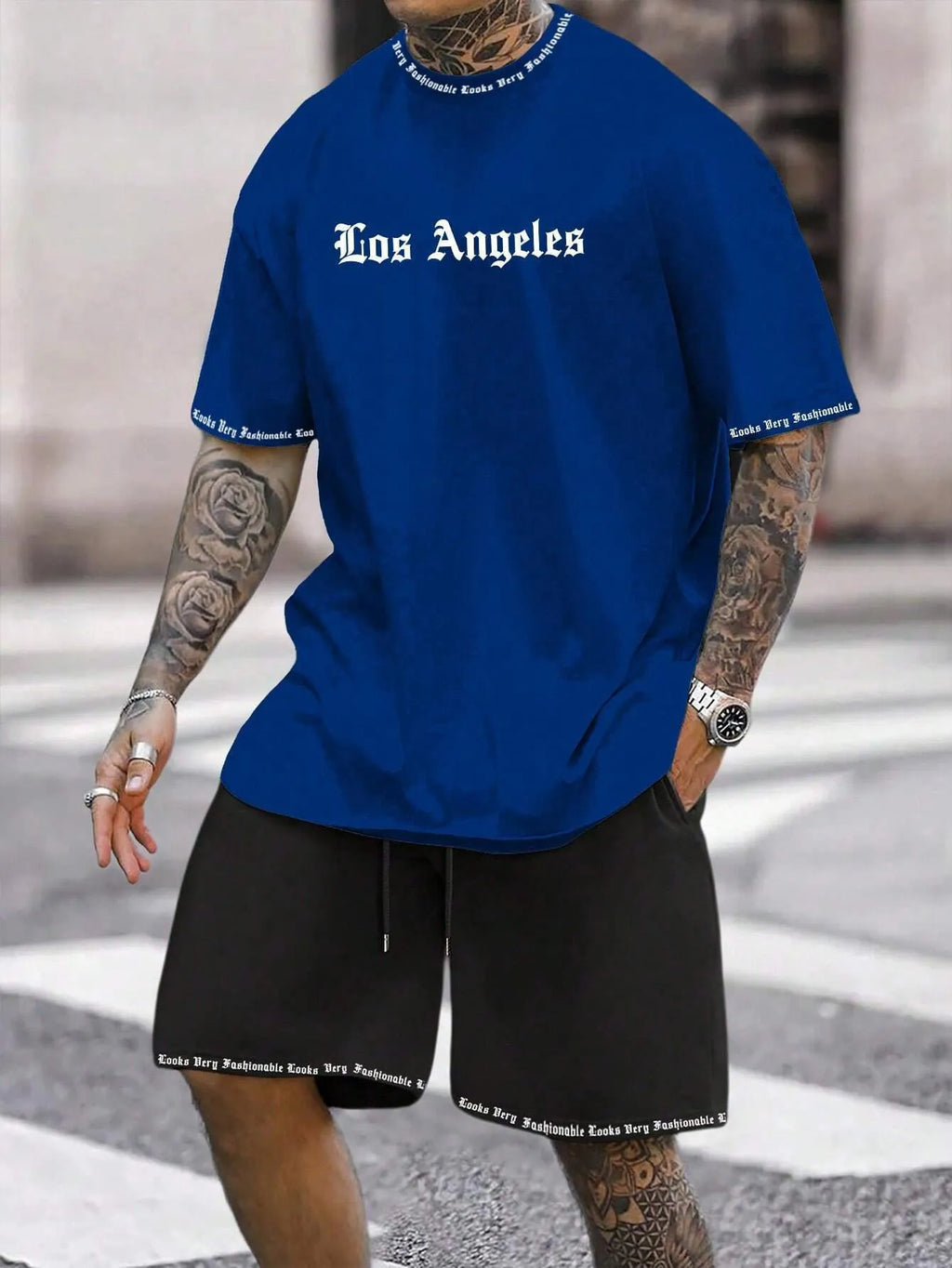 Man wearing a blue printed short-sleeved top and matching shorts from a sports-style two-piece set