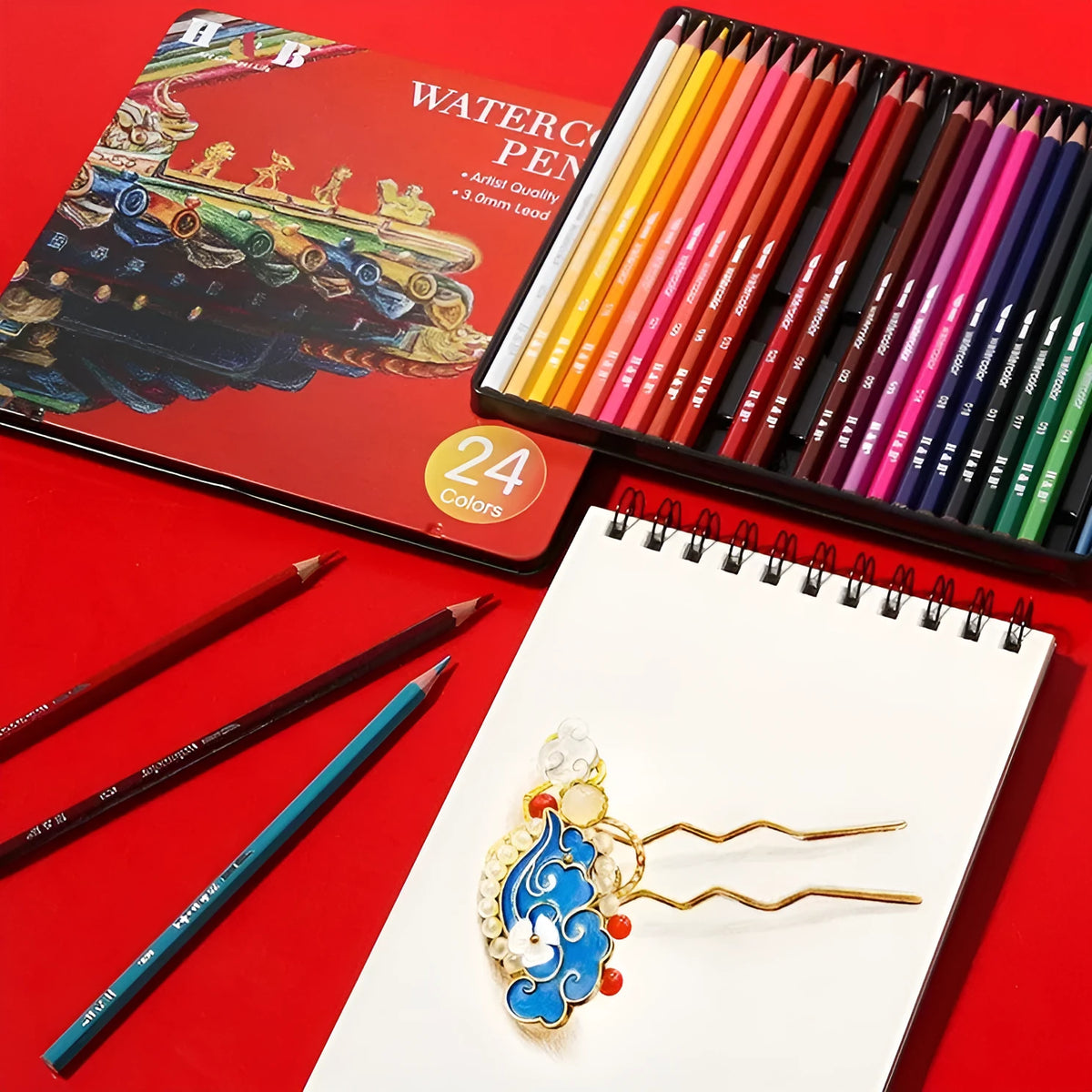 Metal tin box open to show 24 water-soluble coloured pencils in various colours