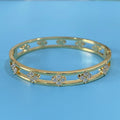 Gold and silver hollow women's bracelets with four-leaf clover zircon charms on a white background.