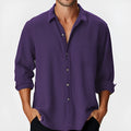Man wearing a solid-colour loose-fit long sleeve casual shirt with a stand collar.