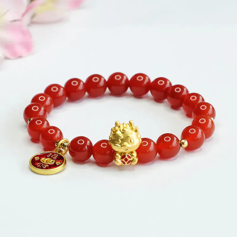 Close-up of a red agate beaded bracelet with a dragon zodiac charm on a wrist.