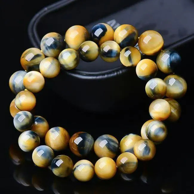 A fantasy tigereye agate bracelet with round beads on a neutral background.