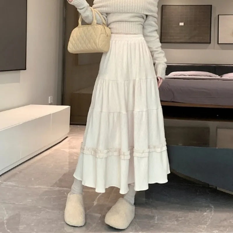 Beige corduroy A-line midi skirt with an elastic waistband on a hanger.