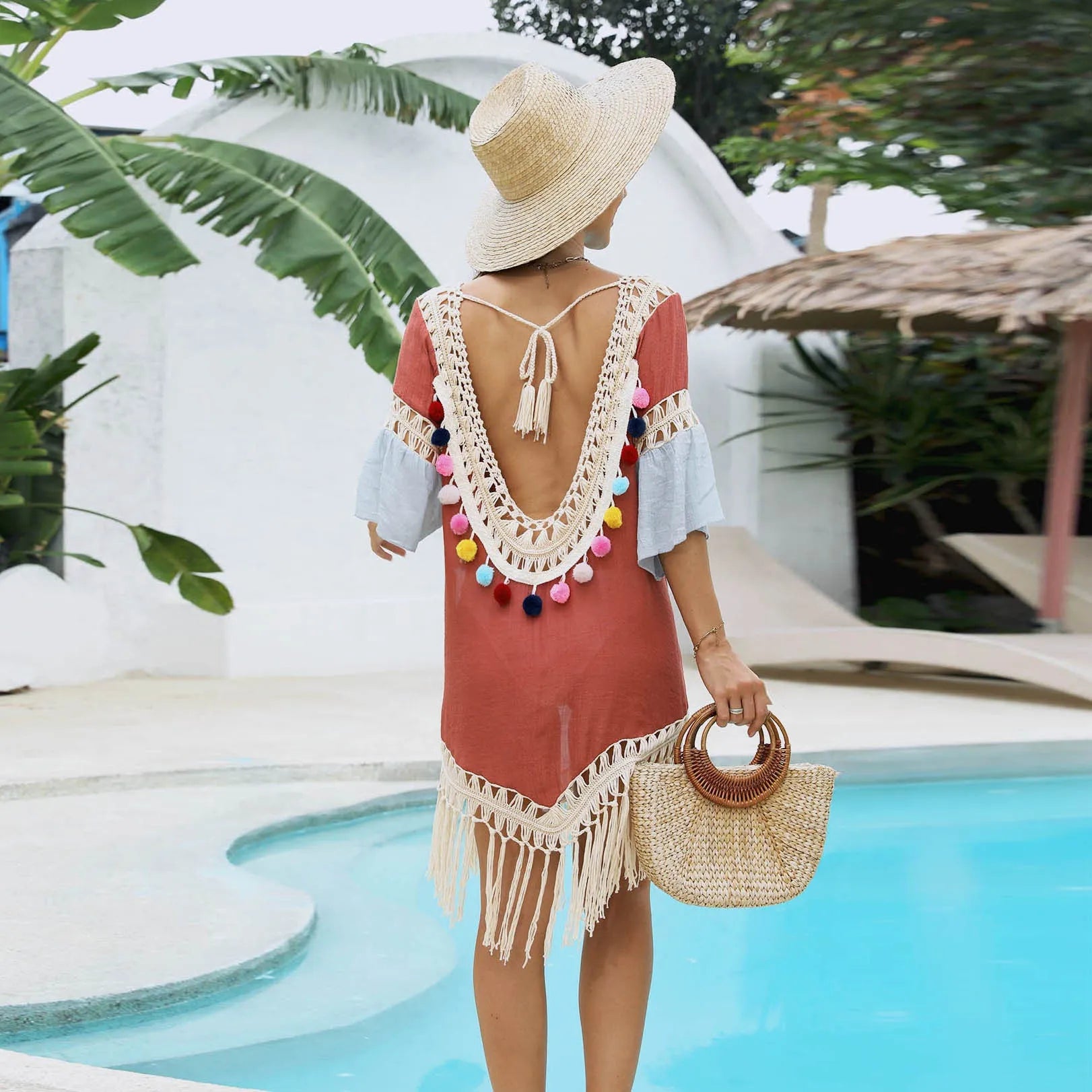 Orange floral pattern beach overskirt with hand crochet detail and cotton tassels laid flat.