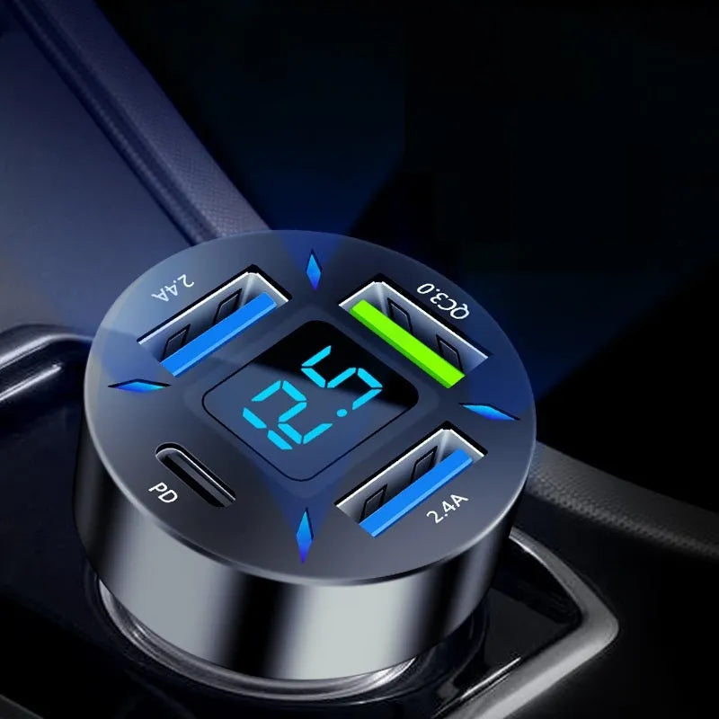 Black four-port USB car charger with LED digital display plugged into a vehicle socket.