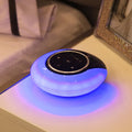 Foldable blue and white Bluetooth desk lamp with speaker, showing touch controls on a desk.