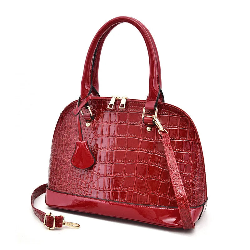 Large shiny PU leather crossbody bag in shell shape design showing black colour option
