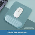 Ergonomic cloth-silicone mouse pad with raised wrist support on a desk