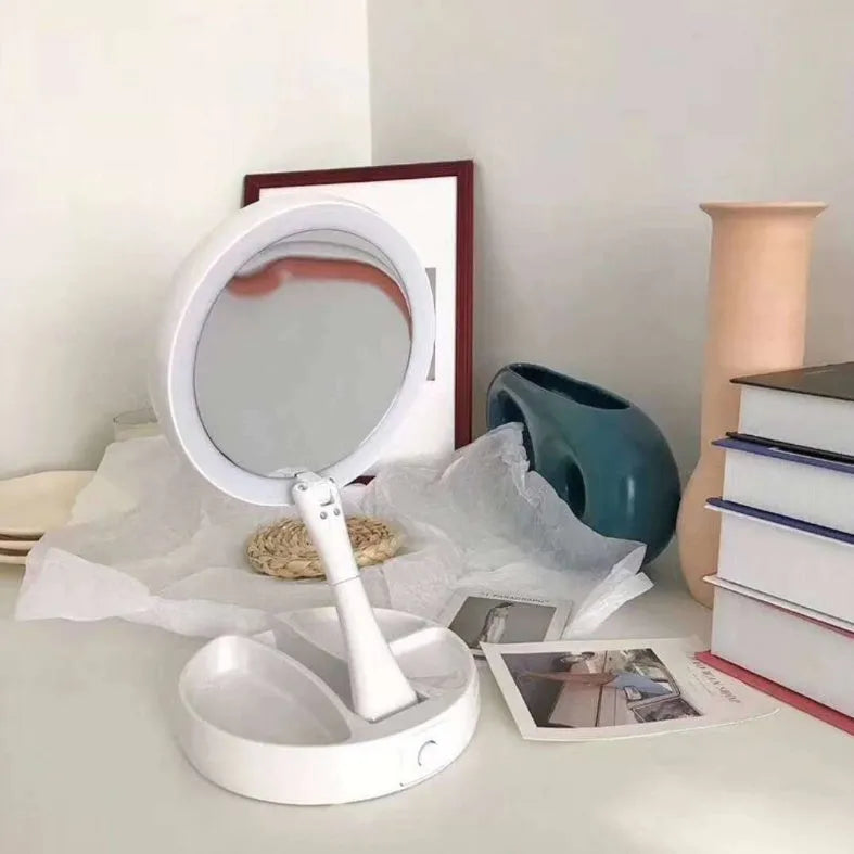 White acrylic foldable LED vanity mirror with USB charging port and double-sided design on a table