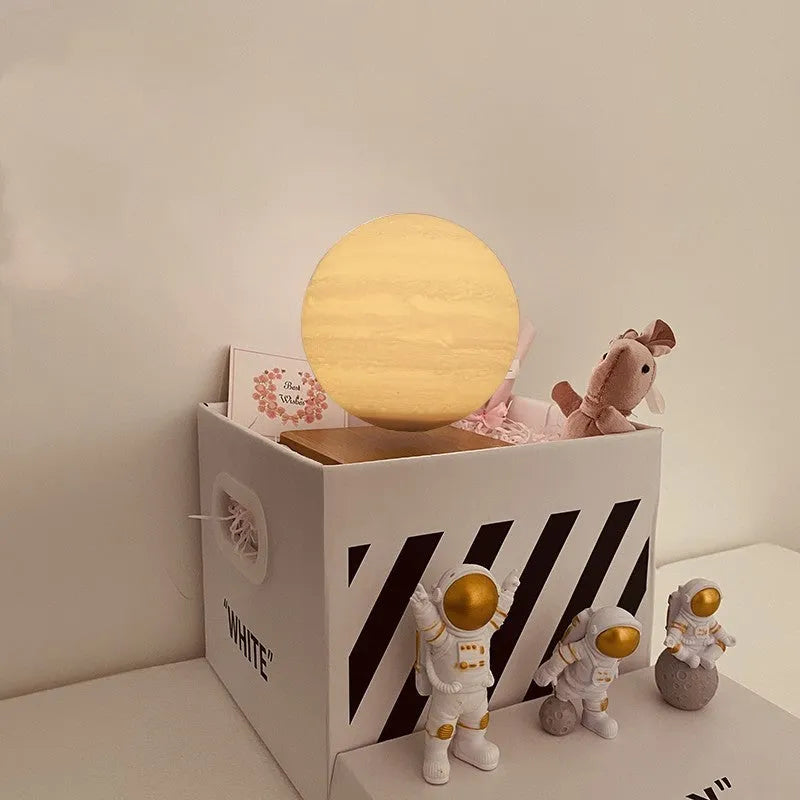 Maglev floating planet night light with LED glow and astronaut figurines on a dark surface.