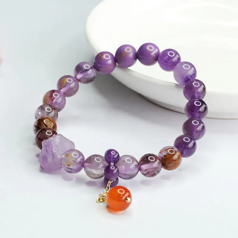 Natural nine purple amethyst and red agate multi-treasure crystal bracelet on wrist.