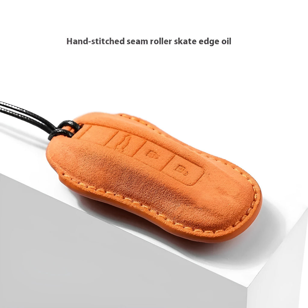 Suede car key cover in cement grey, dark green, light grey, and orange colour options