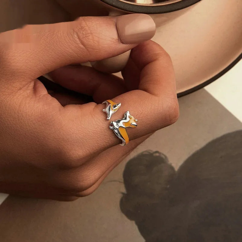 Cartoon-style silver corgi dog ring on a plain background.