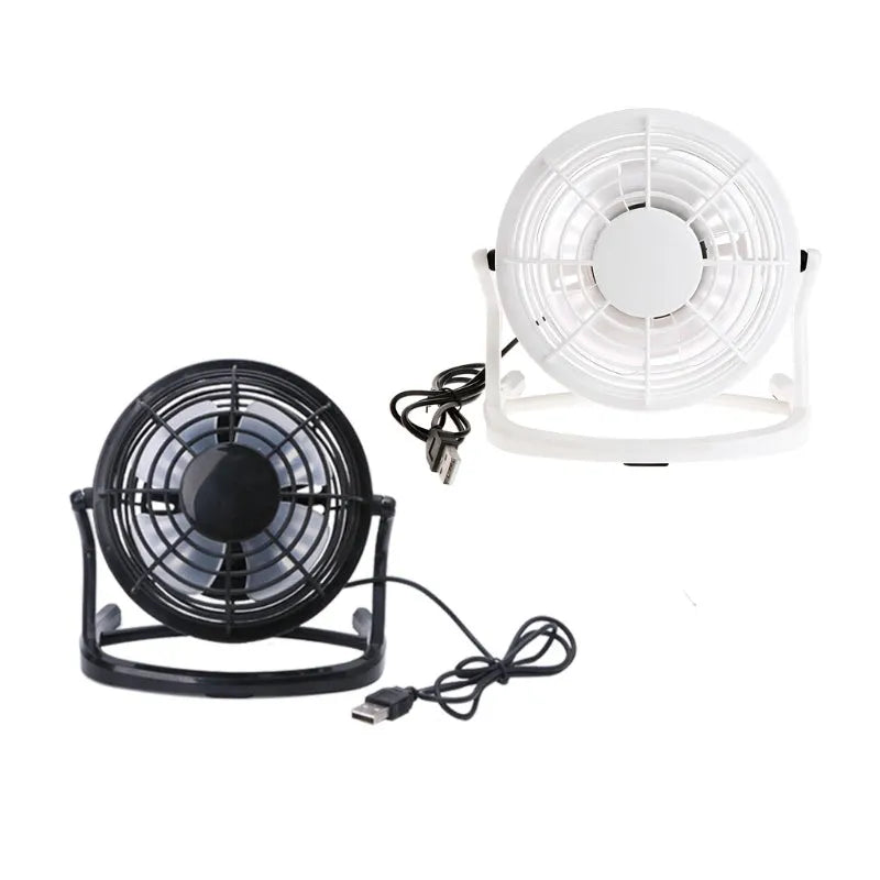 Mini black USB desk fan with adjustable angle on wooden desk next to laptop