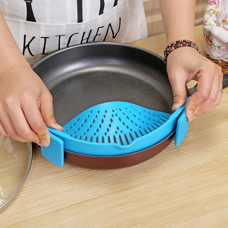 Silicone clip-on funnel strainer attached to kitchen pot for draining liquids