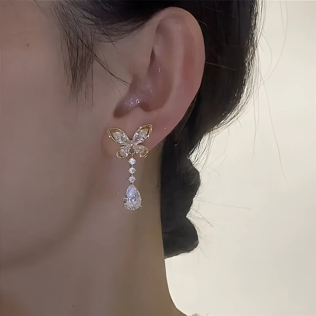A pair of women's bow-shaped stud earrings with a platinum-coloured electroplated finish.