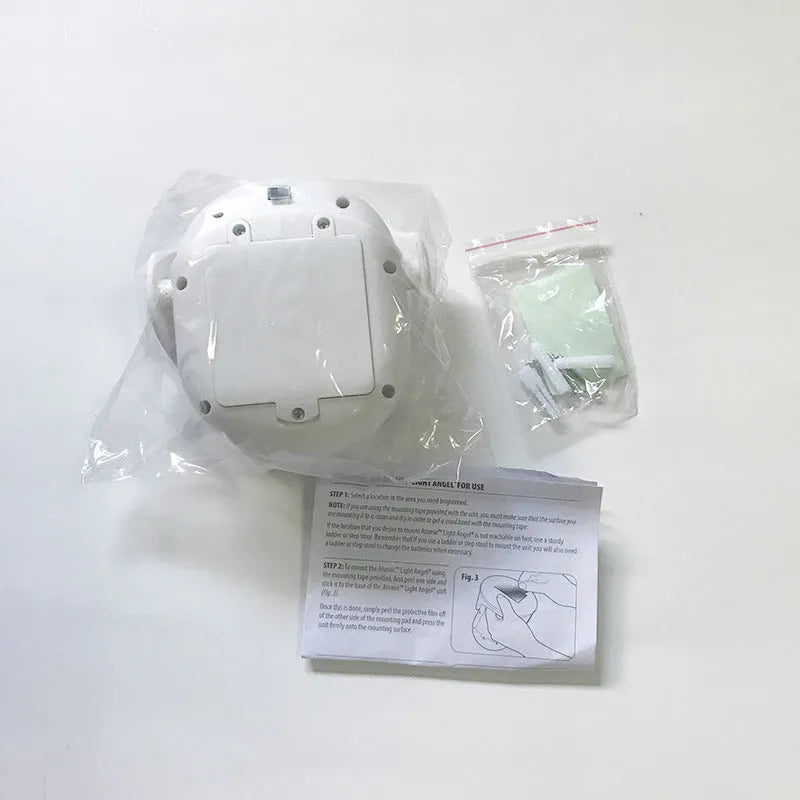 White Atomic Angel induction LED night light with touch sensor on front.
