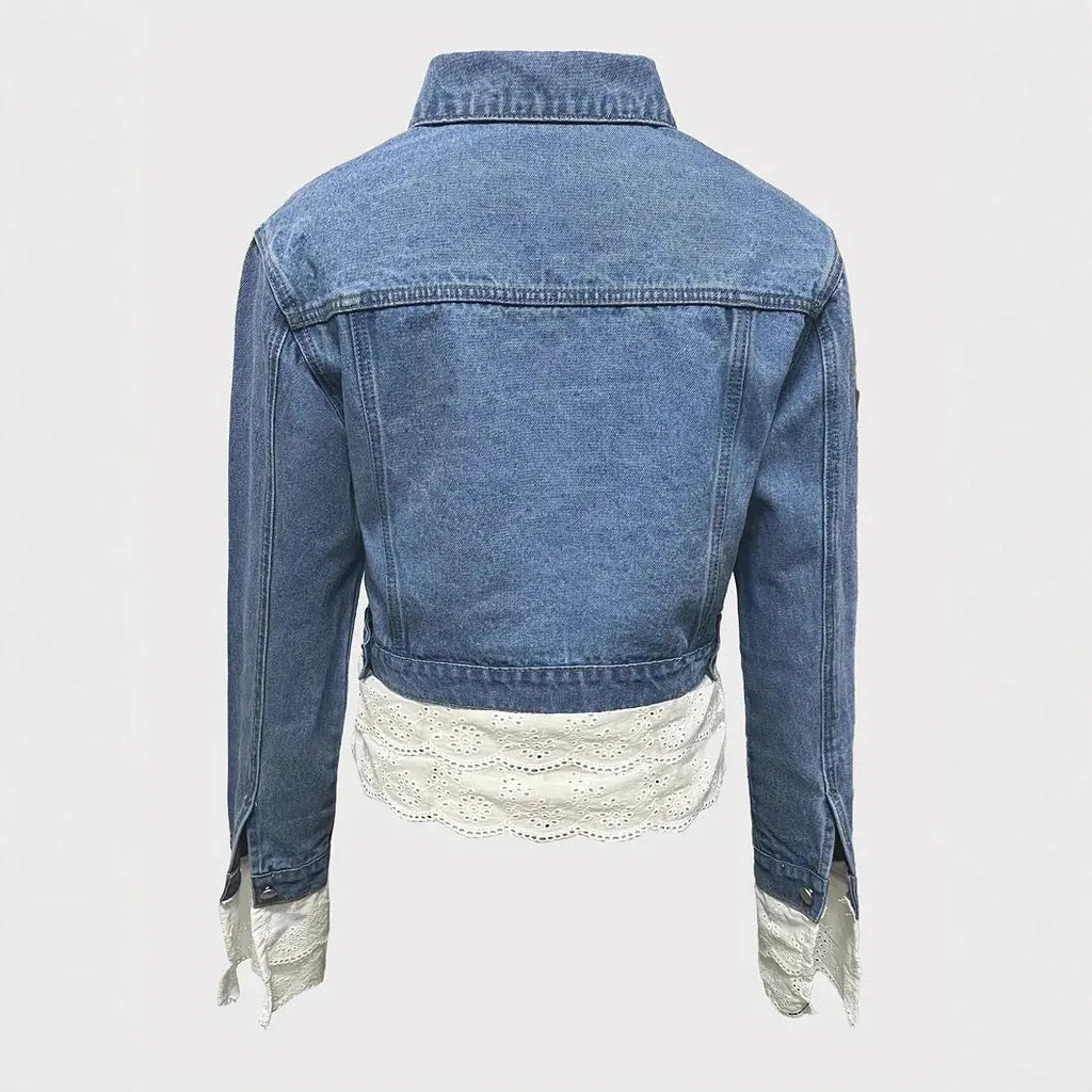 Blue women's denim jacket with lace stitching detail on front, long sleeves, shown on hanger