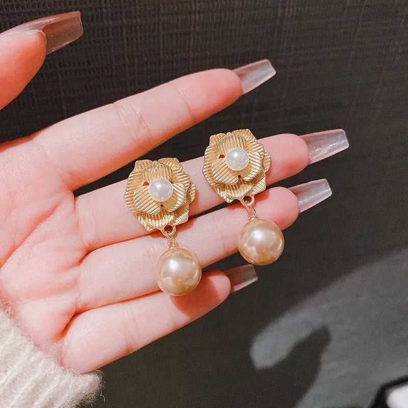 Gold floral stud earrings with rose pearl design, ice flower details, and a central opal stone.