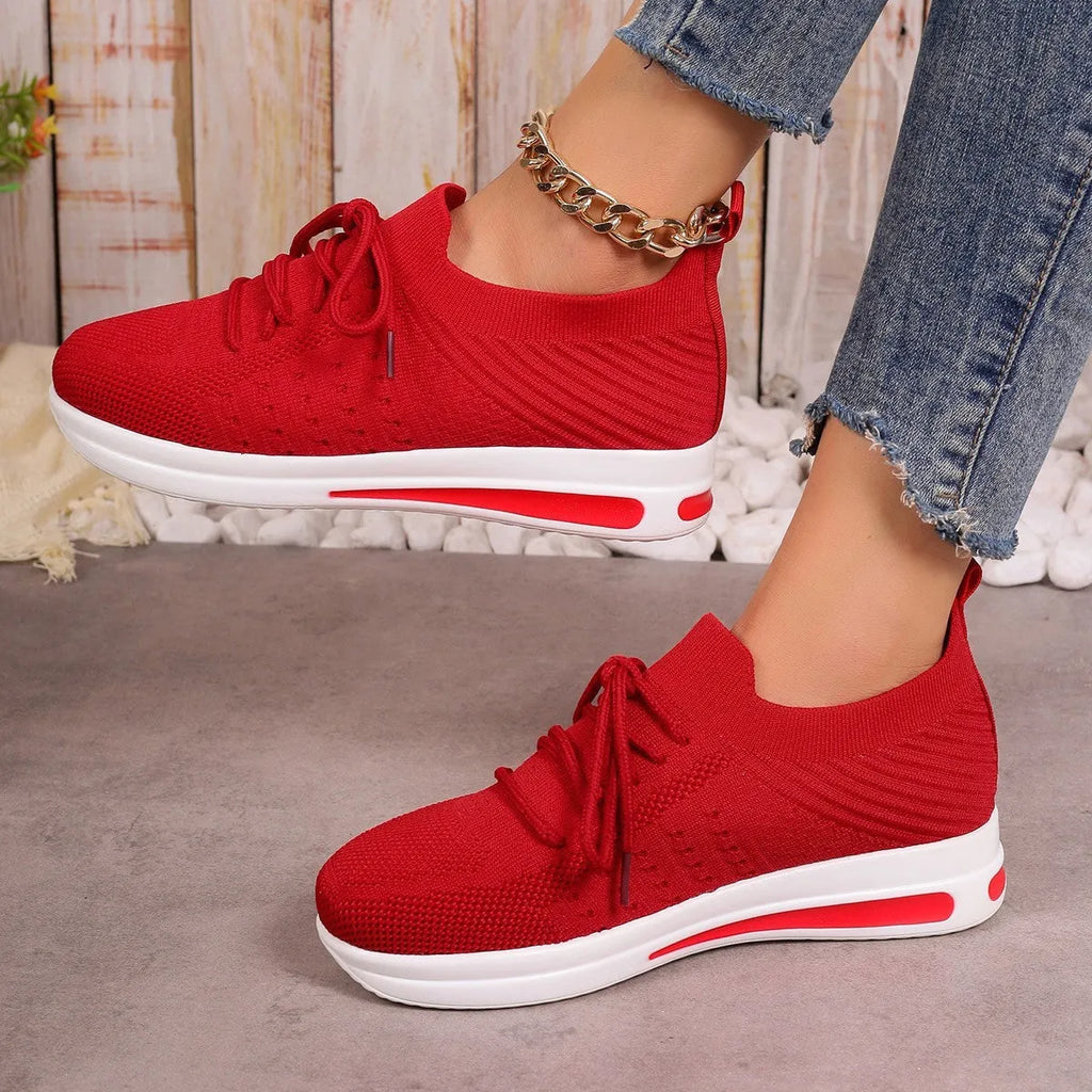 Women's low-top fly-knit style sneakers in black, blue, and red colours with round toe and lace-up front.