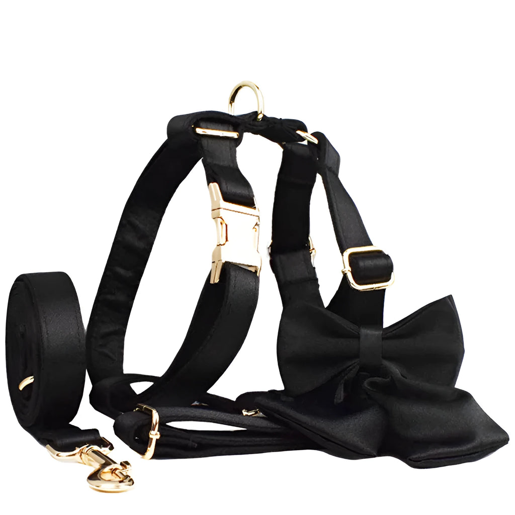 A cloth dog collar, matching leash, decorative bow, and dog vest set laid out flat, showing the coordinated design.