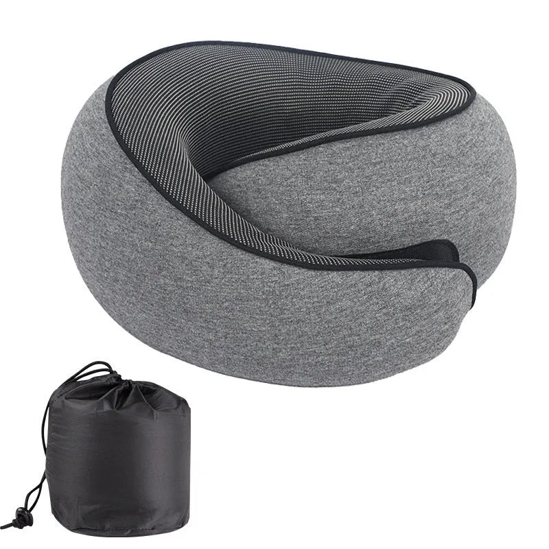 Black memory foam U-shaped travel neck pillow with a storage bag, shown for scale.