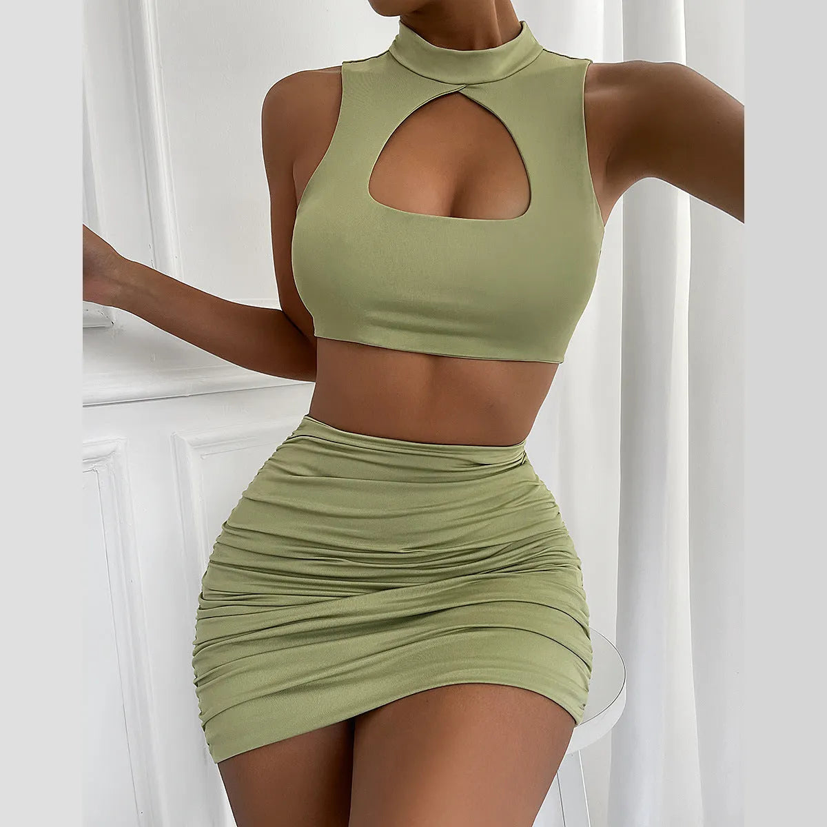 Women's light purple two-piece set with hollow vest top and split skirt on a model.