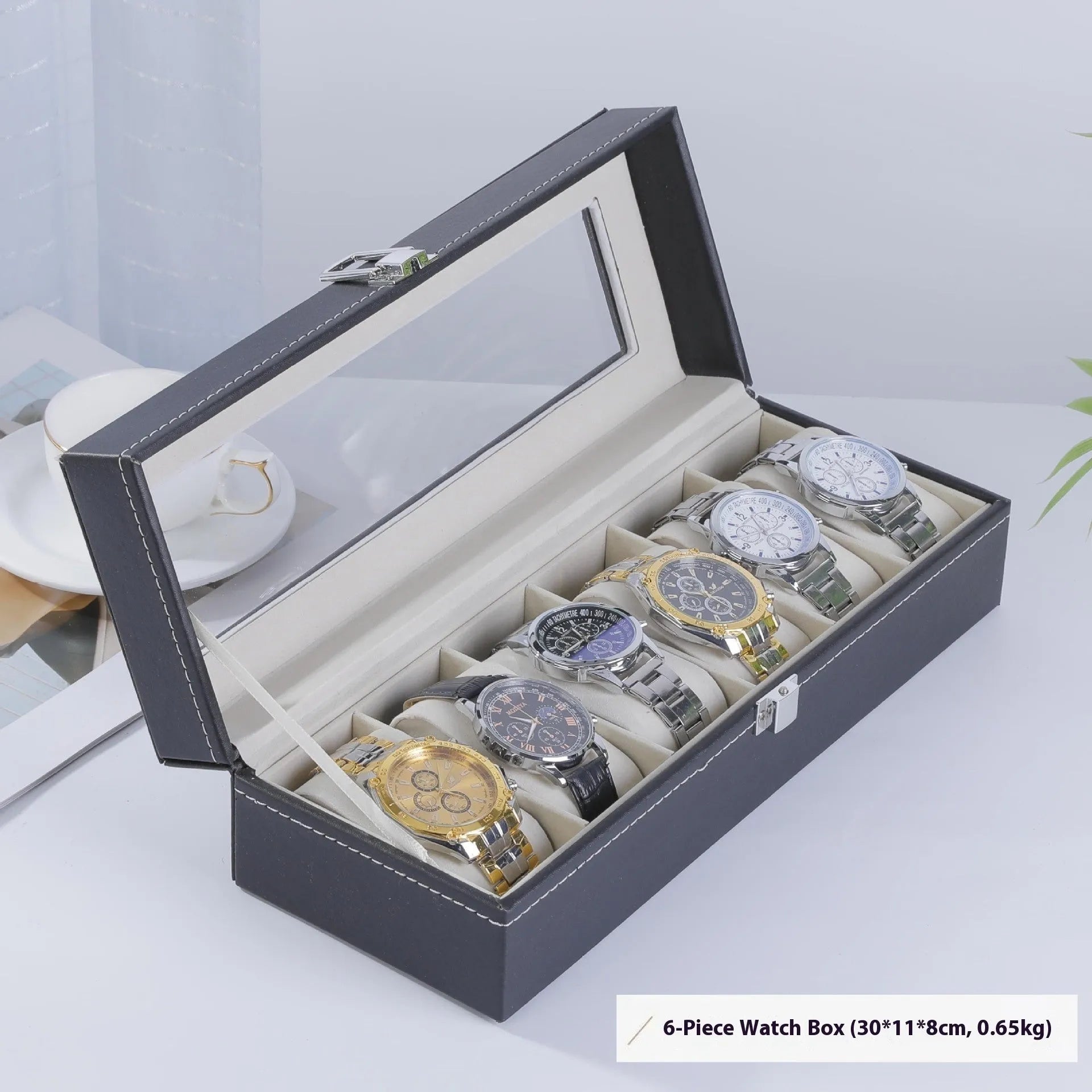 Grey leather watch storage box with transparent lid showing internal watch slots.