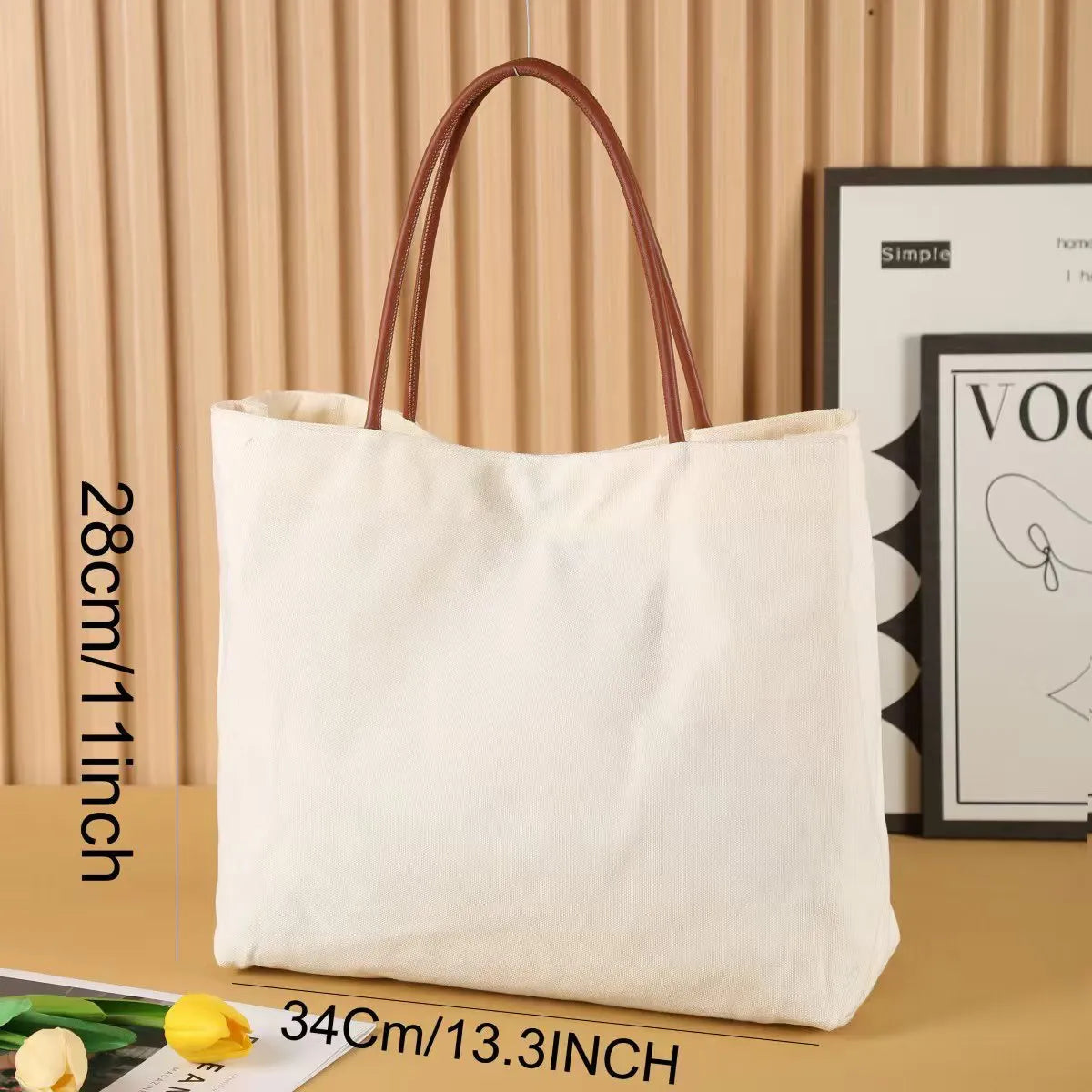 Beige white canvas tote bag with adjustable cotton handles showing reinforced bottom stitching.