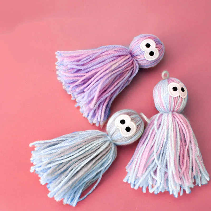 Hanging wool ball cat toy with teaser stick in pink and blue colours on a white background.