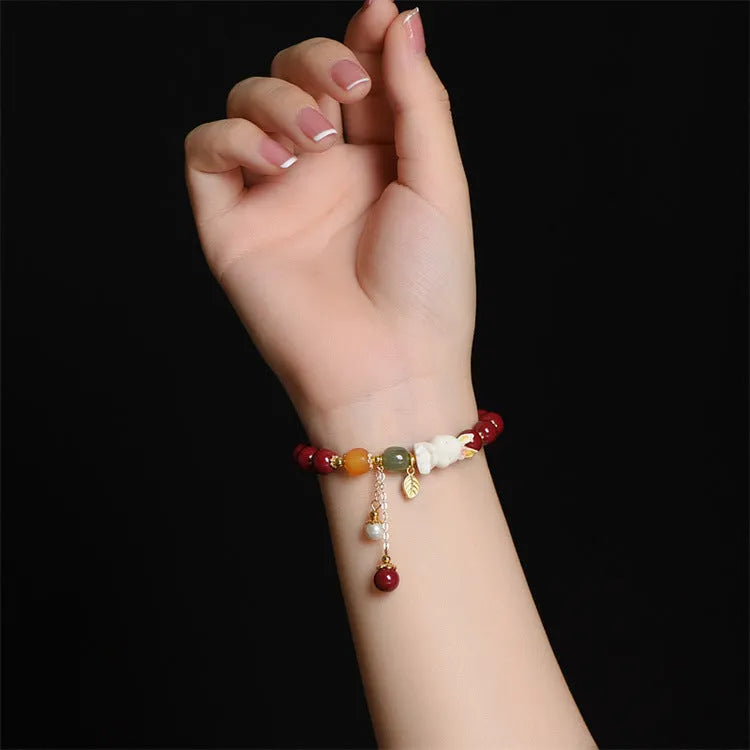 Natural cinnabar bracelet with rabbit charm for women, shown in 8mm and 10mm bead size options.